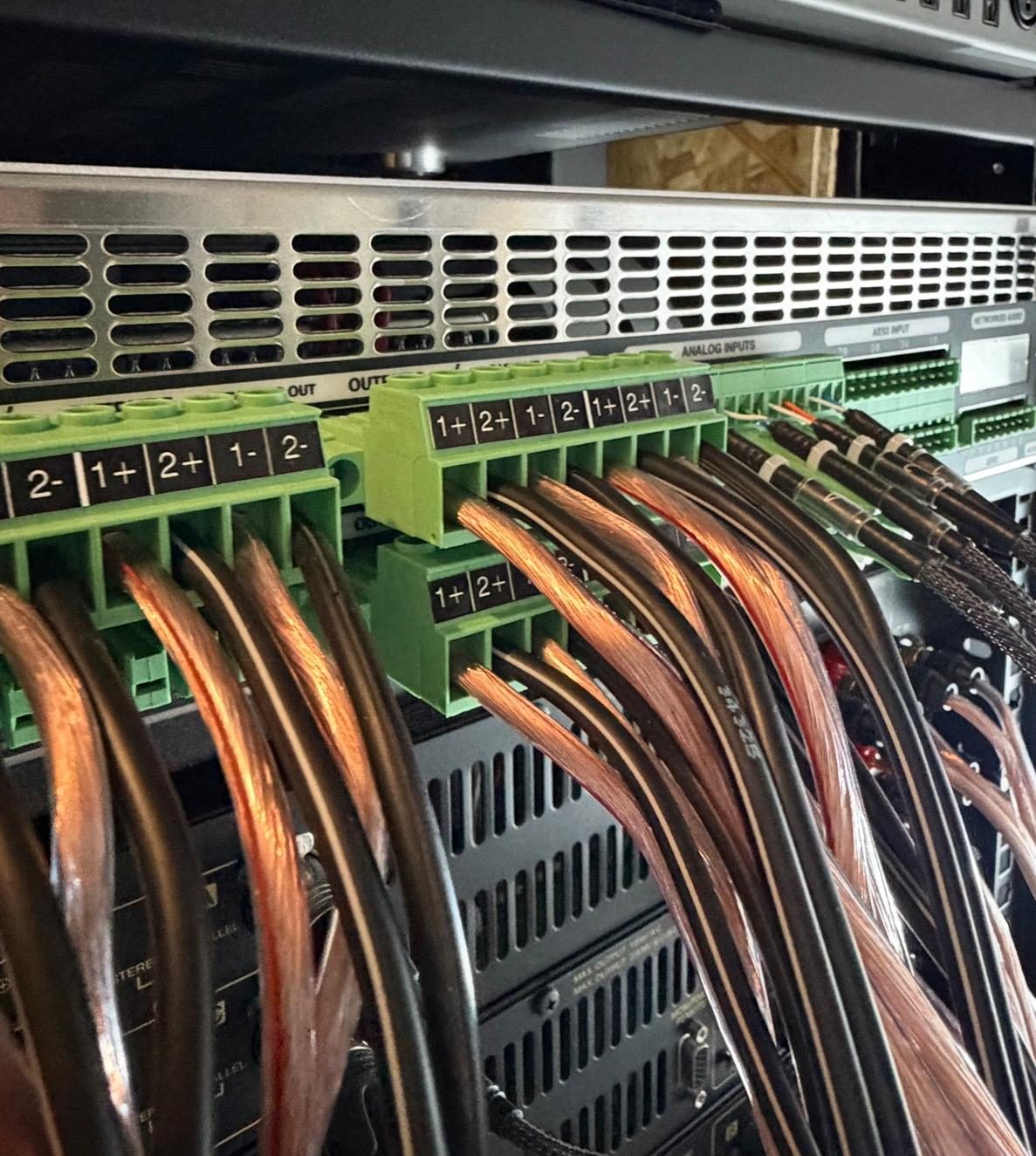 Câblage de puissance à l'arrière d'un rack d'amplification multicanal, borniers repérés canal par canal