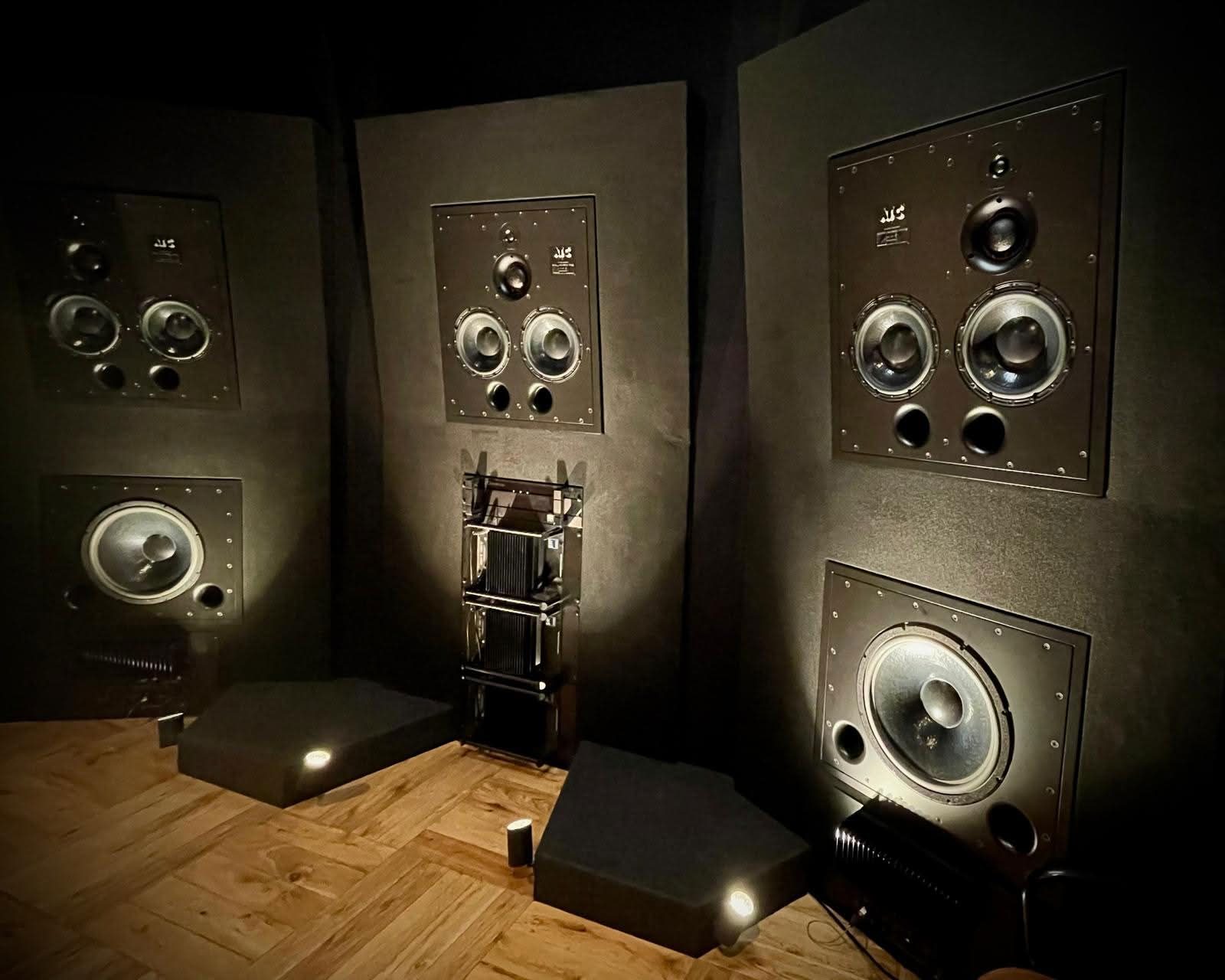 Listening room in Paris, speakers flush-mounted in the walls with subwoofers on the floor